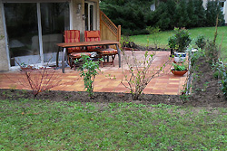 Fertige Terrasse mit frisch angelegter Randbepflanzung